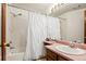 Cozy bathroom featuring a shower-tub combo with white shower curtain and a wooden cabinet and pink countertop at 14271 E Dickinson Dr # F, Aurora, CO 80014