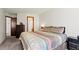 Inviting bedroom showcases plush bedding, dark carpet and a dresser with a doorway view to the bathroom at 14271 E Dickinson Dr # F, Aurora, CO 80014