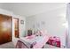 Cozy bedroom featuring a pink bed, stuffed animals, and a wooden door at 14271 E Dickinson Dr # F, Aurora, CO 80014