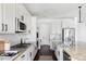 Bright kitchen with stainless steel appliances, granite countertops, modern lighting, and a tiled backsplash at 19503 W 58Th Pl, Golden, CO 80403