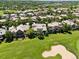 Aerial view of a luxury home nestled in a golf course community, surrounded by lush greenery at 9171 E Harvard Ave, Denver, CO 80231