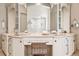 Elegant bathroom vanity with dual sinks, ornate mirrors and fixtures with a basket under the vanity at 9171 E Harvard Ave, Denver, CO 80231
