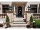 Elegant front entrance featuring a decorative iron door, stone columns, and manicured landscaping at 9171 E Harvard Ave, Denver, CO 80231