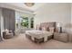 Bright main bedroom with bay window, tray ceiling, stylish chandelier, and neutral decor at 9171 E Harvard Ave, Denver, CO 80231