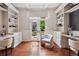 Inviting home office featuring custom built-in shelving, hardwood floors, and a stylish chair at 9171 E Harvard Ave, Denver, CO 80231