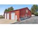 Exterior of a large red barn with solar panels and three garage doors at 97 S Coolidge St, Aurora, CO 80018