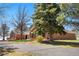 Charming brick home exterior with lush landscaping, mature trees, and a well-manicured lawn at 97 S Coolidge St, Aurora, CO 80018