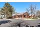 Exterior of the home featuring a brick facade, three-car garage, and a well-maintained driveway at 97 S Coolidge St, Aurora, CO 80018