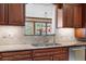 A close up of a granite countertop with a stainless steel kitchen sink, and mahogany cabinets at 97 S Coolidge St, Aurora, CO 80018