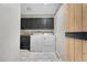 Modern laundry room with front loading washer and dryer, custom cabinets, and stylish wallpaper at 97 S Coolidge St, Aurora, CO 80018