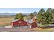 View of property with a red barn and brick house on a sunny day at 97 S Coolidge St, Aurora, CO 80018