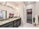 Modern bathroom with double sink vanity, granite countertop, decorative plants and walk-in closet at 6153 N Ceylon St # 303, Denver, CO 80249