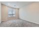 Bright bedroom with a large window offering natural light and plush gray carpeting at 6153 N Ceylon St # 303, Denver, CO 80249