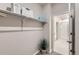 Open closet with shelf and storage accessories adjacent to a bathroom with glass shower door at 6153 N Ceylon St # 303, Denver, CO 80249