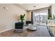 Comfortable living room with stylish teal chairs, a round coffee table, and a sliding glass door leading to a balcony at 6153 N Ceylon St # 303, Denver, CO 80249