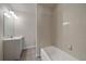 Bright bathroom featuring a tub with tiled surround and modern vanity with great lighting at 8329 W 90Th Pl, Westminster, CO 80021