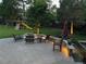 Tranquil backyard with a stone seating area, a playground set, and ambient lighting throughout at 5329 S Geneva St, Englewood, CO 80111