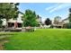 Expansive backyard features a lush lawn, mature trees, and a patio with outdoor dining and grilling space at 5329 S Geneva St, Englewood, CO 80111