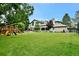 A well-maintained backyard with a large lawn, mature trees, and a playset for fun and recreation at 5329 S Geneva St, Englewood, CO 80111