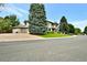 Expansive property featuring a meticulously kept lawn with mature trees and a circular driveway at 5329 S Geneva St, Englewood, CO 80111