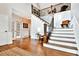 Grand foyer with hardwood floors, staircase with iron railing, and wainscoting detail at 5329 S Geneva St, Englewood, CO 80111