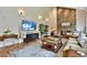 Open living room with hardwood floors, a stone fireplace, and a large TV at 5329 S Geneva St, Englewood, CO 80111