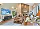 Bright living room with stone fireplace, hardwood flooring, and a large TV at 5329 S Geneva St, Englewood, CO 80111