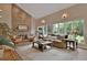 Inviting living room featuring a stone fireplace, hardwood flooring, large windows, and natural light at 5329 S Geneva St, Englewood, CO 80111