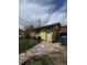 Detached garage with a single entry door and mature trees providing shade at 1395 Havana St, Aurora, CO 80010