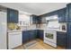 Well-equipped kitchen featuring navy cabinets, modern appliances, and hardwood floors at 2752 S Heather Gardens Way, Aurora, CO 80014