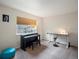 Cozy bedroom with a piano, desk, and comfortable seating area by the window at 7400 W Grant Ranch Blvd # 19, Littleton, CO 80123