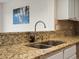 Granite countertops and stainless steel dual sink with contemporary faucet in this updated kitchen at 7400 W Grant Ranch Blvd # 19, Littleton, CO 80123