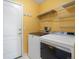 Convenient laundry room features a side-by-side washer and dryer, shelving, and an exterior door at 7400 W Grant Ranch Blvd # 19, Littleton, CO 80123
