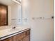Bathroom featuring a single sink vanity with a large mirror and neutral color palette at 3873 W 98Th Ave, Westminster, CO 80031