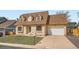 Traditional brick home with an attached garage and mature trees, showcasing a blend of comfort at 3873 W 98Th Ave, Westminster, CO 80031