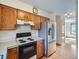 Kitchen featuring wood cabinets, white countertops, and appliances, with wood flooring extending into the adjacent room at 3873 W 98Th Ave, Westminster, CO 80031