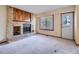 Living room with brick fireplace and wood mantel, window, and a white door at 3873 W 98Th Ave, Westminster, CO 80031