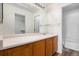 Bright bathroom featuring a large mirror, wood vanity, and a combined tub and shower at 19172 E Arkansas Dr # 106, Aurora, CO 80017