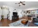 Open-concept living space with hardwood floors, a fireplace, and a dining area in the background at 4401 Hydrangea Way, Castle Rock, CO 80109