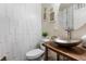 The stylish powder room features a hammered metal sink, a custom wood vanity and a decorative accent wall at 4401 Hydrangea Way, Castle Rock, CO 80109