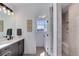 A sleek bathroom with a walk-in shower, a single vanity, and modern lighting at 785 Delechant Dr, Erie, CO 80516