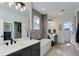 A luxurious bathroom featuring a soaking tub, double vanity, and contemporary fixtures at 785 Delechant Dr, Erie, CO 80516