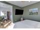 The bedroom has an olive green wall, and a mounted television for cozy, modern viewing at 785 Delechant Dr, Erie, CO 80516