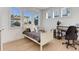 A well-lit bedroom with large windows, a work desk, and cozy decor with a queen sized bed at 785 Delechant Dr, Erie, CO 80516