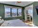 A bright bedroom with a view from the three windows, hardwood floors, and an adjacent room at 785 Delechant Dr, Erie, CO 80516