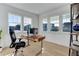 Bright home office featuring a sleek desk, modern chair, and large windows offering abundant natural light at 785 Delechant Dr, Erie, CO 80516
