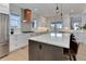 A modern kitchen featuring white cabinets, stainless steel appliances, and a stylish island with pendant lighting at 785 Delechant Dr, Erie, CO 80516