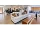 Bright living room featuring hardwood floors, a comfortable sofa, and seamless flow to dining and outdoor spaces at 785 Delechant Dr, Erie, CO 80516