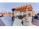 Outdoor kitchen and patio area with a pergola, ideal for grilling and entertaining in a serene backyard setting at 785 Delechant Dr, Erie, CO 80516