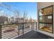 Cozy balcony with iron railings offering city views through a bare tree and a large window at 1878 W 32Nd Ave, Denver, CO 80211